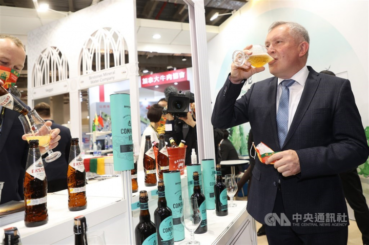 Lithuanian Vice Minister of Agriculture Egidijus Giedraitis (right) drinks a glass of beer when visiting the stand showcasing products from the Baltic nation at the Food Taipei exhibition Wednesday. CNA photo June 22, 2022