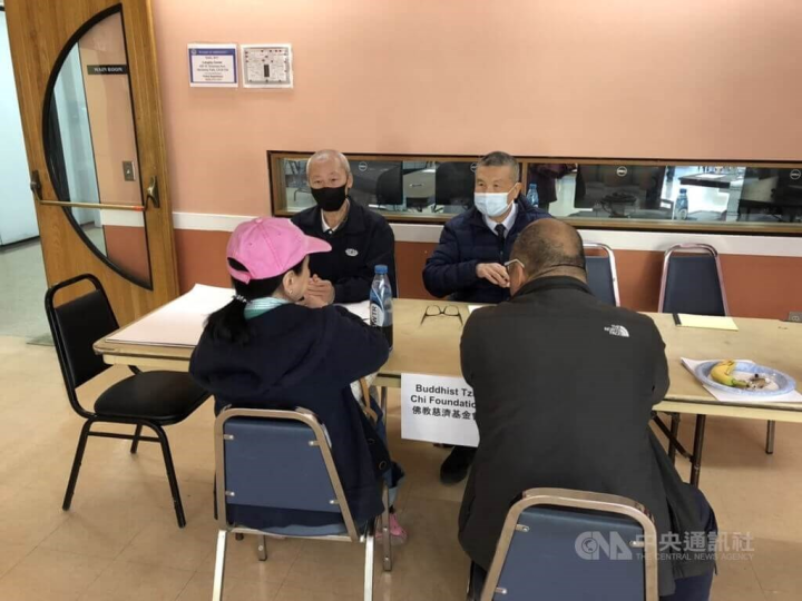 Tzu Chi volunteers speaking with victims (backs facing the camera). Photo courtesy of the Tzu Chi Foundation
