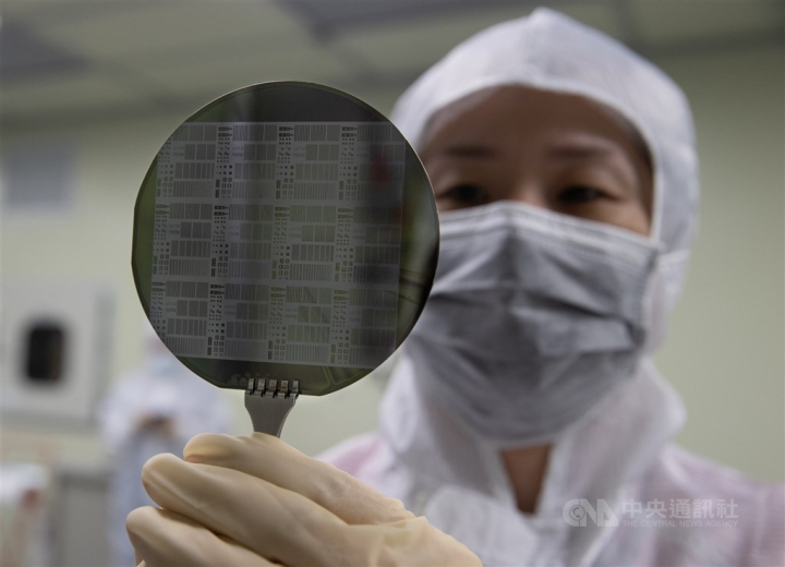 An engineer at a Taiwanese tech firm inspects a silicon wafer. 